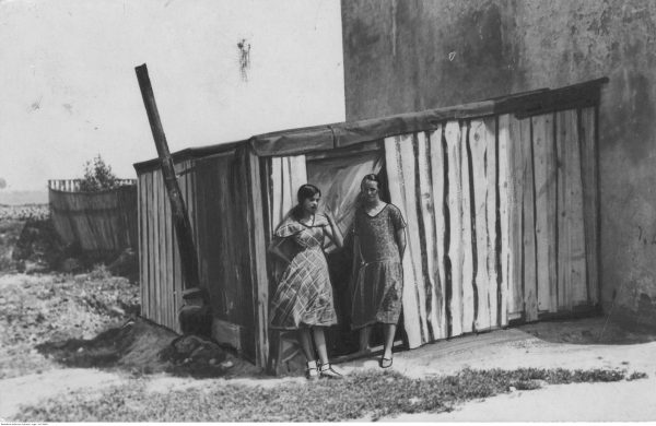Dwie bezrobotne kobiety przed drewnianą szopą służącą im za mieszkanie. Lata 20.-30.