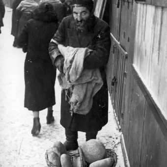 Żyd handlujący chlebem na ulicy. Fotografia z okresu II wojny światowej.