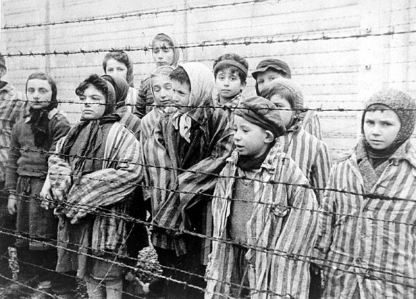 Dzieci za drutami obozu. Zdjęcie stanowi kadr z sowieckiego filmu dokumentującego wyzwolenie Auschwitz. 