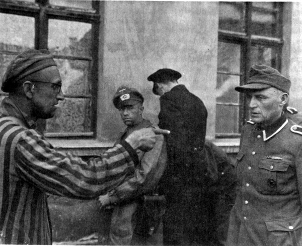 Ocalony z Buchenwaldu wskazuje palcem obozowego strażnika, który znany był z brutalności względem więźniów (fot. domena publiczna)
