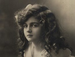 Dziewczyna z koszyczkiem kwiatków. Fotografia z początku XX wieku