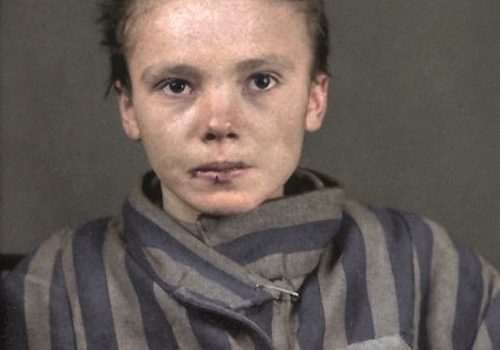 Więźniarka Auschwitz Czesława Kwoka w pasiaku, z widocznym czerwonym trójkątem i numerem obozowym.