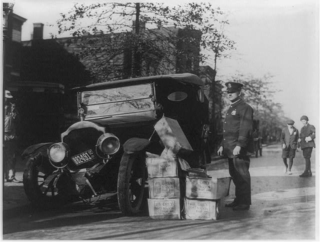 Policjant z wrakiem samochodu i skonfiskowanym bimbrem, 1922.